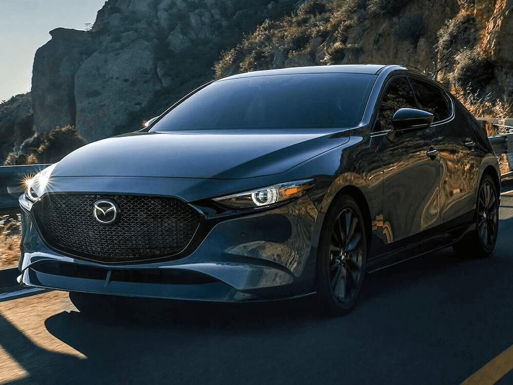 Vue 3/4 avant du Mazda3 Sport 2025 sur la route.