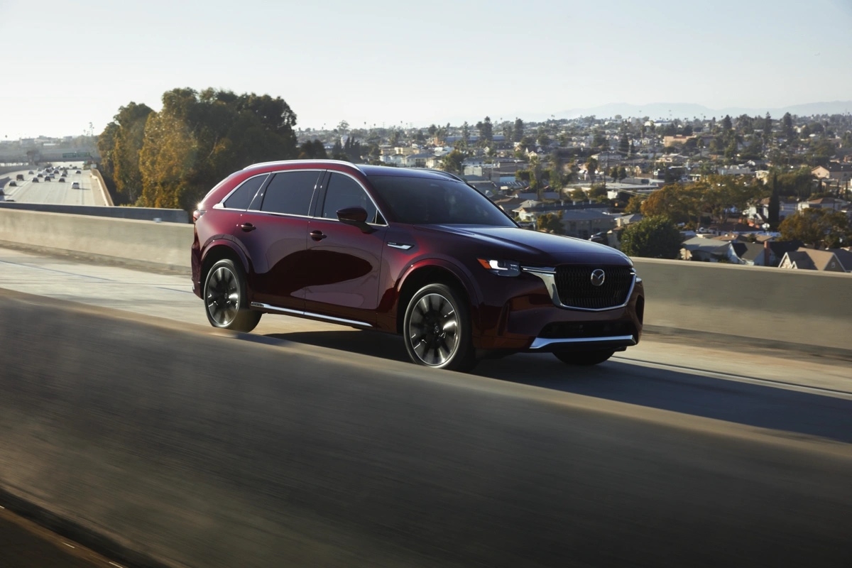 Mazda CX-90 2025 en mouvement sur l’autoroute, VUS intermédiaire familial et élégant.