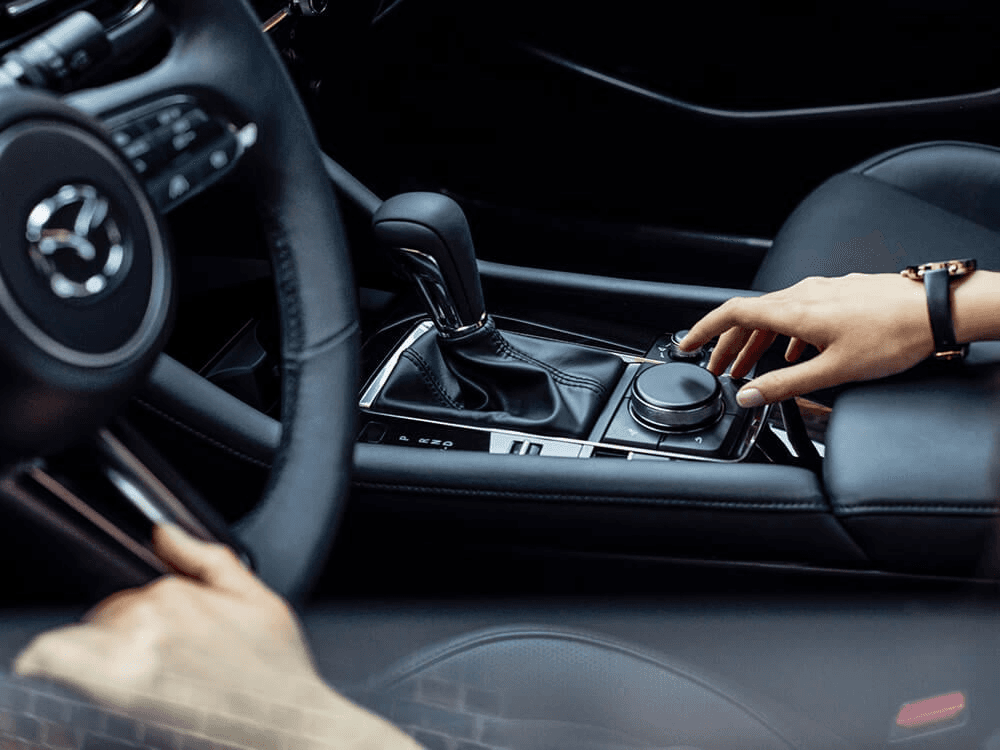 Main à la console de changement de vitesse de la Mazda3 2024.