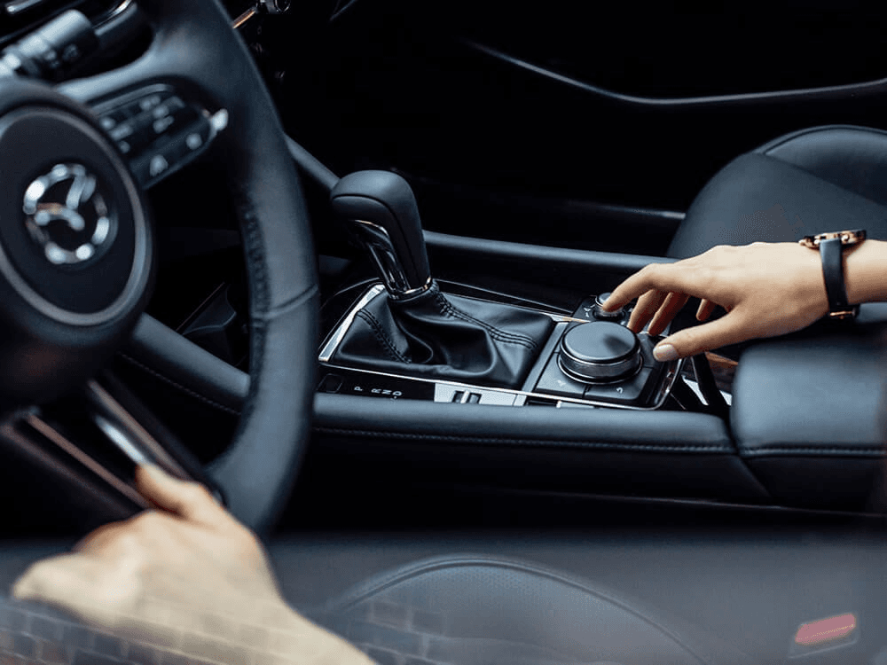 Main à la console de changement de vitesse de la Mazda3 2025.