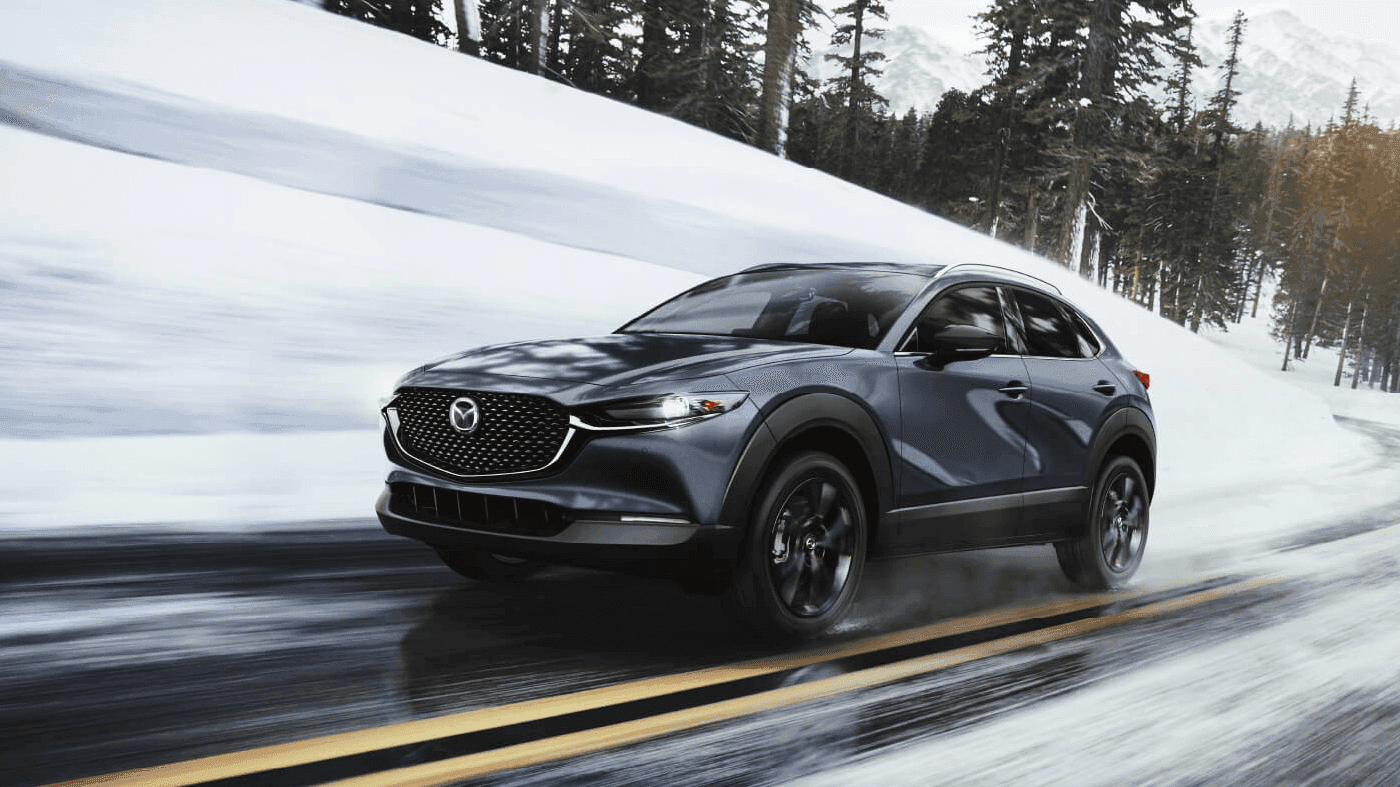 Vue 3/4 avant et latérale du Mazda CX-30 2025 sur route en pleine puissance