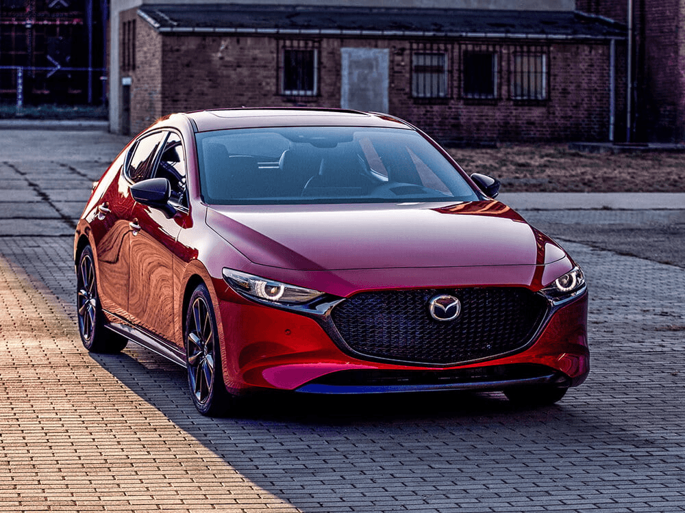 Vue 3/4 avant du Mazda3 Sport 2025 sur un pavé.